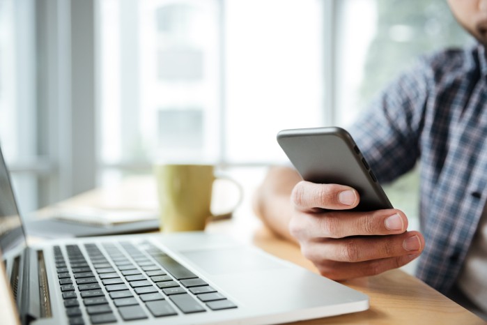 young-man-using-laptop-computer-phone.jpg